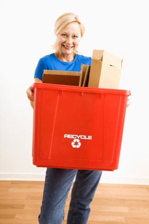 Woman holding recycling bin.